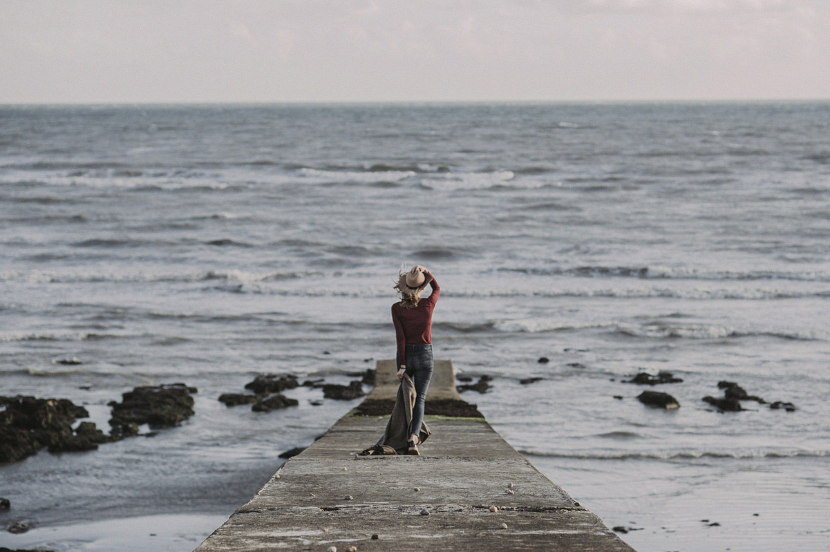 Person Standing on Dock Holding Textile